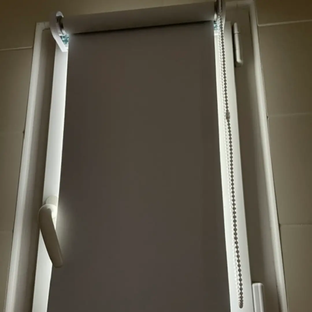 Store enrouleur occultant semi fermé fenêtre de salle de bain